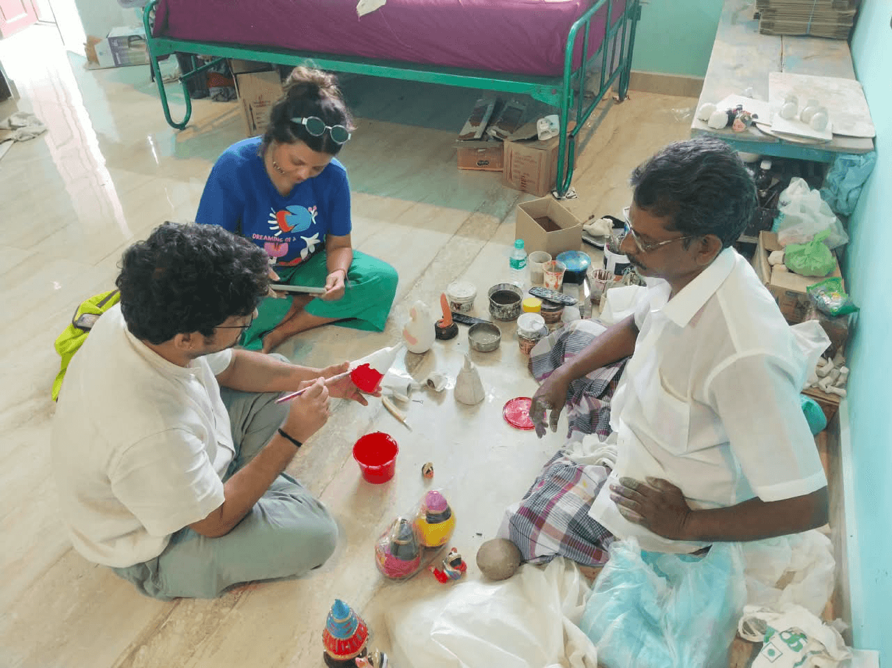 Travellers painting their own Thanjavur dolls with bright colours